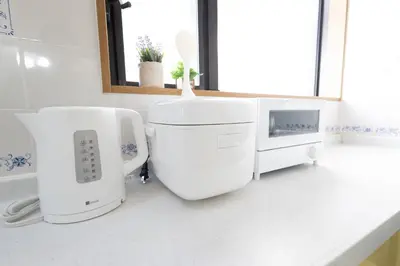 a white bathroom with a sink and a microwave at Sui HOUSE \u5317\u8d64\u7fbd in Tokyo
