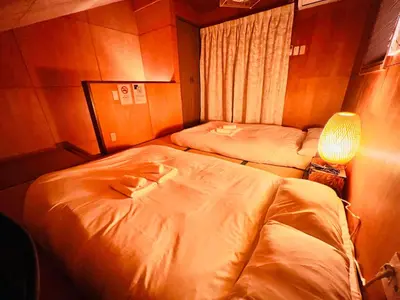 a room with two beds and a lamp in it at Sui HOUSE \u5317\u8d64\u7fbd in Tokyo
