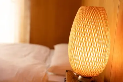 a lamp sitting on a table next to a bed at Sui HOUSE \u5317\u8d64\u7fbd in Tokyo