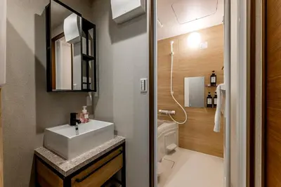 a bathroom with a sink and a toilet and a mirror at \u30d9\u30eb\u30d3\u30e5\u30fc\u516b\u5e83 in Tokyo