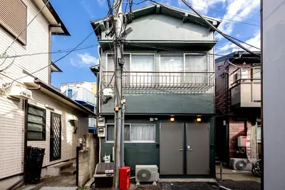 a building with a green door in a street at \u30d9\u30eb\u30d3\u30e5\u30fc\u516b\u5e83 in Tokyo