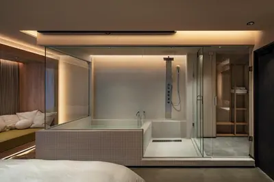 a glass shower with a tub in a bedroom at HotelCO Kuramae \u30db\u30c6\u30eb \u30b3 \u8535\u524d in Tokyo