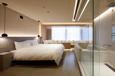 a bedroom with a white bed and a glass shower at HotelCO Kuramae \u30db\u30c6\u30eb \u30b3 \u8535\u524d in Tokyo