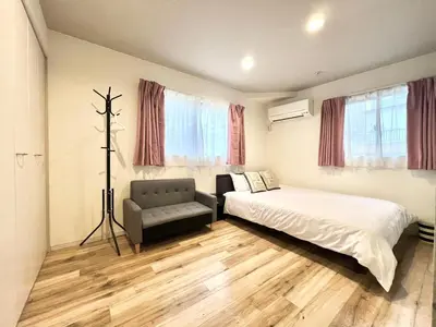 a bedroom with a bed and a chair and windows at Ichigayayanagichō 牛込柳町一户建-SJ0186 in Tokyo