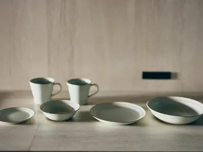 four bowls and cups sitting on a wooden table at illi Enu Yotsuya in Tokyo