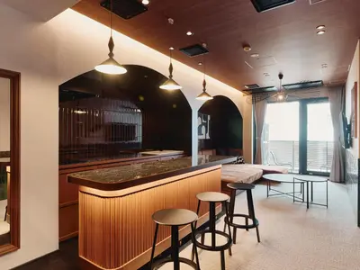 a kitchen with a bar with stools and tables at illi Enu Yotsuya in Tokyo
