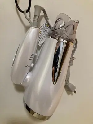 a silver tea kettle hanging on a wall at \u6885\u5c4b\u6577\u8cb8\u6238\u5efa in Tokyo