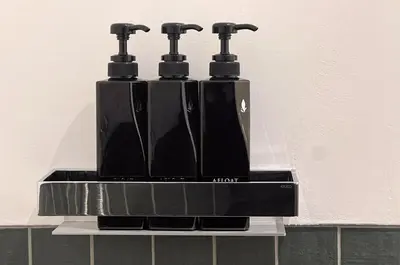a black holder with three drinking bottles on a wall at TOsuiKYO in Tokyo