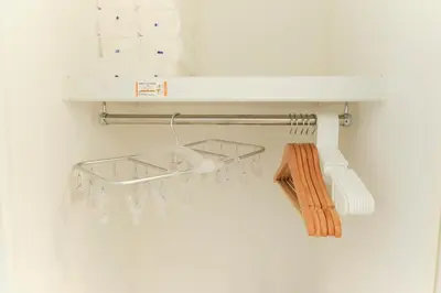 a towel rack with a white shelf on a wall at Hotel Dieu Nakanobu by Tranova in Tokyo