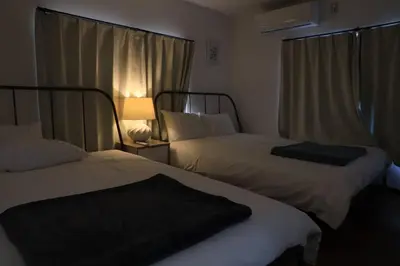 a hotel room with two beds and a lamp at 8路線使用可能！アクセス抜群/池袋駅より徒歩5分/最大11名/Wi-Fi完備/まるごと3LDK in Tokyo
