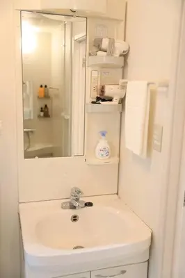 a white bathroom with a sink and a mirror at 8路線使用可能！アクセス抜群/池袋駅より徒歩5分/最大11名/Wi-Fi完備/まるごと3LDK in Tokyo