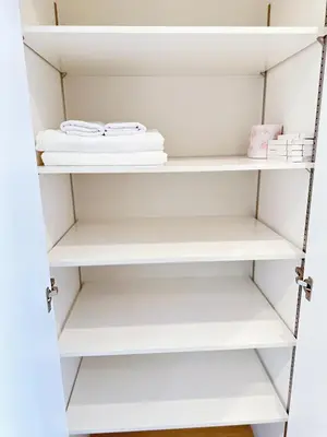a closet with white shelves and towels at Base36 in Tokyo