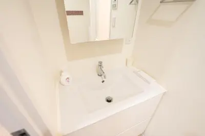 a white bathroom with a sink and a mirror at Base36 in Tokyo