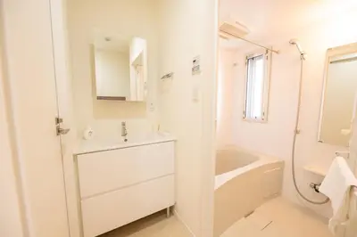 a white bathroom with a sink and a bath tub at Base36 in Tokyo