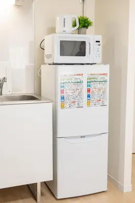 a microwave sitting on top of a refrigerator at Base36 in Tokyo