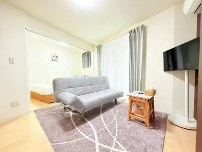 a living room with a couch and a tv at Base36 in Tokyo
