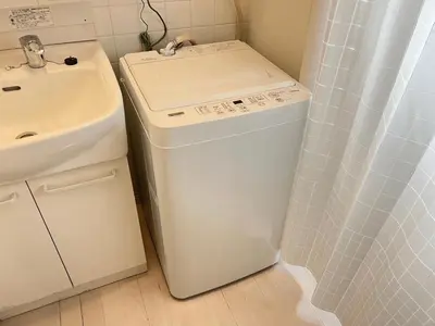 a washer and dryer in a bathroom next to a sink at \u5927\u5c71\u753a\u6238\u5efa in Tokyo