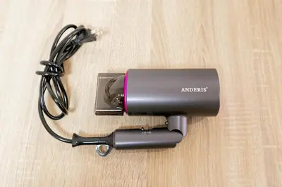 a camera sitting on a wooden table with a charger at Liberty Corp 101 - Vacation STAY 16233 in Tokyo
