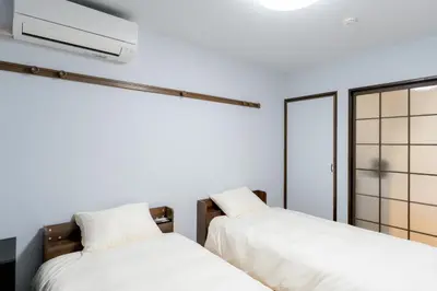 two beds in a room with white walls at Liberty Corp 101 - Vacation STAY 16233 in Tokyo