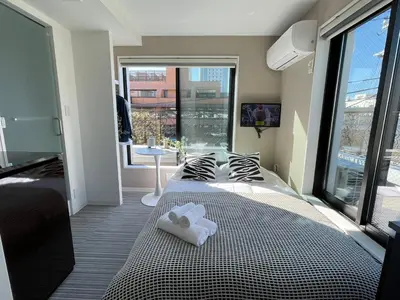 a bedroom with a bed with two towels on it at COMMA HOUSE Shinjuku 402 in Tokyo