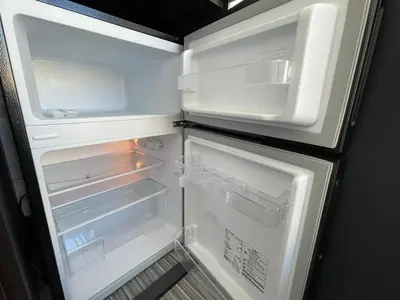 an open refrigerator with its door open and its contents at COMMA HOUSE Shinjuku 402 in Tokyo