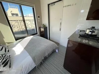 a bedroom with a bed and a large window at COMMA HOUSE Shinjuku 402 in Tokyo