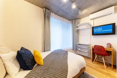 a bedroom with a bed and a tv on a wall at Dash Living Kagurazaka in Tokyo