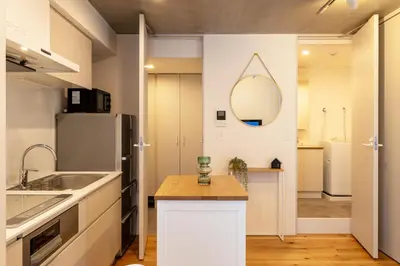 a kitchen with a sink and a mirror on the wall at Dash Living Kagurazaka in Tokyo