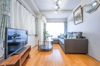 a living room with a couch and a flat screen tv at 東京の中心地の新宿区で便利/2駅から徒歩6分/6名収容/無制限高速WIFI in Tokyo