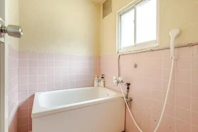 a bathroom with a tub and a window and pink tiles at 東京の中心地の新宿区で便利/2駅から徒歩6分/6名収容/無制限高速WIFI in Tokyo