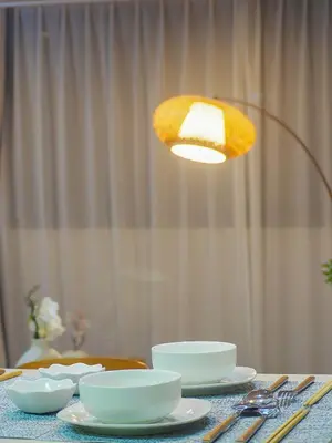 a table with plates and bowls and a light at \u685c\u306e\u5ddd17 JR\u4e0a\u91ce\u99c53\u5206\u949f 13\u4eba\u623f 5LDK 110\u5e73\u522b\u5885\u4e28Ueno Villa 3 minutes from Ueno Station 13 people in Tokyo