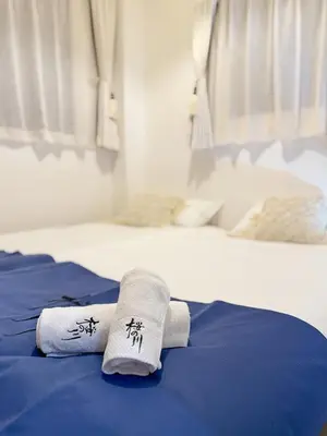 two white towels on a bed with blue sheets at \u685c\u306e\u5ddd17 JR\u4e0a\u91ce\u99c53\u5206\u949f 13\u4eba\u623f 5LDK 110\u5e73\u522b\u5885\u4e28Ueno Villa 3 minutes from Ueno Station 13 people in Tokyo