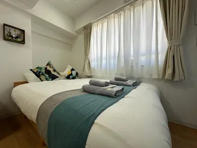 a bedroom with a large bed with towels on it at nestay miriz tokyo ikebukuro in Tokyo