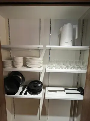 a kitchen cabinet with plates and dishes on shelves at MANGA ART HOTEL, BAKUROCHO in Tokyo