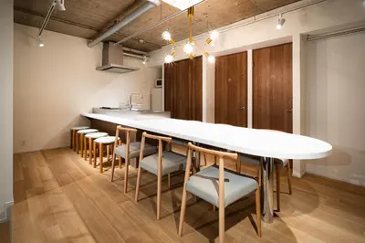 a kitchen with a large white table and chairs at MANGA ART HOTEL, BAKUROCHO in Tokyo