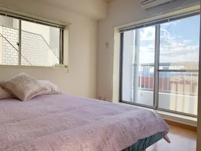 a bedroom with a bed and a large window at \u7cbe\u54c1\u65b0\u88c5\u4fee60\u5e73\u7c732\u5367\u5ba4\u9633\u5149\u516c\u5bd3#\u5e72\u6e7f\u5206\u79bb#\u9ad8\u901f\u65e0\u9650\u5236\u7f51\u8def#\u4e13\u7528\u7535\u68af\u76f4\u8fbe#3\u7ad9\u76f4\u8fbe\u65b0\u5bbf#\u6700\u59277\u4eba#itk501 in Tokyo
