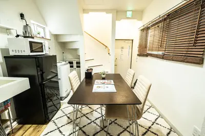 a kitchen with a table with chairs and a microwave at 18, Oji B, Detached house for rent, \u738b\u5b50B in Tokyo
