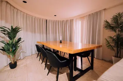 a wooden table in a room with chairs and plants at One Shibuya Hill: Urban Oasis in Tokyo