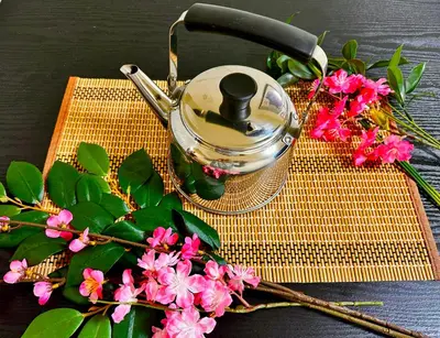 a tea kettle and flowers on a yellow mat at Relax place in Tokyo