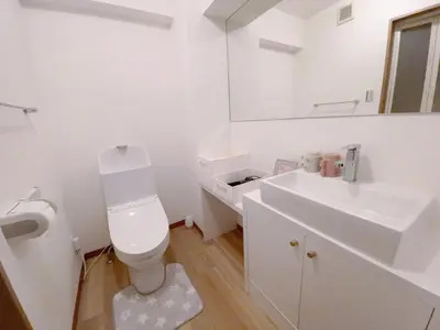 a white bathroom with a toilet and a sink at Sunshine in Tokyo