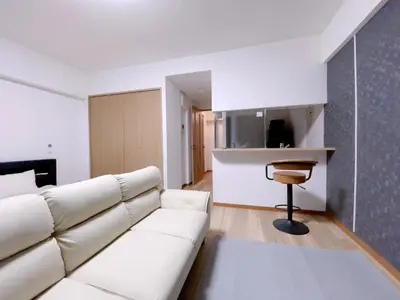 a living room with a white couch and a stool at Sunshine in Tokyo
