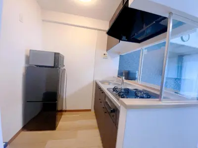 a small kitchen with a refrigerator and a sink at Sunshine in Tokyo
