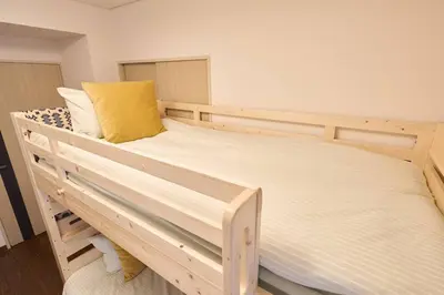 a wooden bunk bed with a yellow pillow on it at Liberty house208 /Shibuya 5min by train Sangenjaya in Tokyo