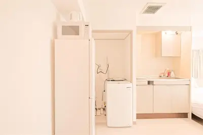a white refrigerator in a kitchen with a microwave at Mi-APT SHIRO in Tokyo