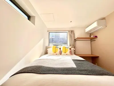 a small bedroom with a bed with a window at Kenki Ueno House-TT0170 in Tokyo