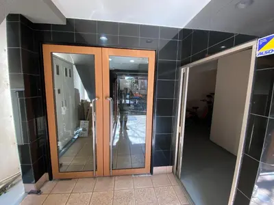 a hallway with two glass doors in a building at walk to JR Shibuya sta.-YoYY in Tokyo