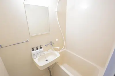 a white bathroom with a sink and a mirror at walk to JR Shibuya sta.-YoYY in Tokyo