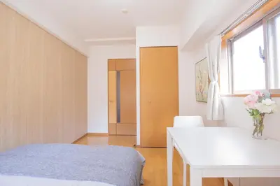 a bedroom with a bed and a desk and a window at walk to JR Shibuya sta.-YoYY in Tokyo