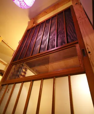 a wooden door with glass windows in a room at Tokyo Hikari Guesthouse in Tokyo