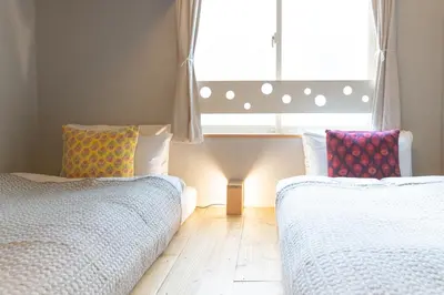 two beds sitting in a room with a window at Tokyo Hikari Guesthouse in Tokyo